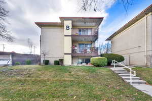 Back of property featuring a balcony and brick siding