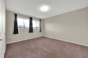 Carpeted empty room with baseboards and a textured ceiling