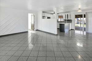 Unfurnished living room featuring granite floors, a ceiling fan, and a textured ceiling