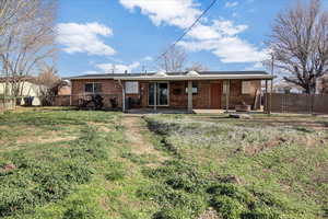 Back of house with a fenced backyard, a patio, and brick siding