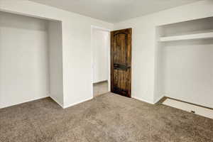 Unfurnished bedroom featuring carpet and baseboards