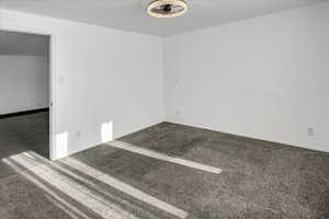 Carpeted spare room featuring a textured ceiling