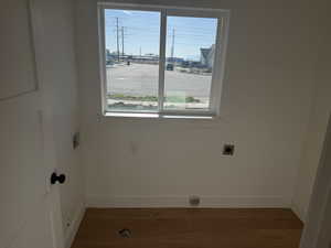 Laundry area featuring light wood-style flooring, washer hookup, and electric dryer hookup