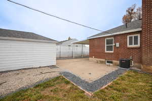 Rear view of house featuring a patio area and a shingled roof