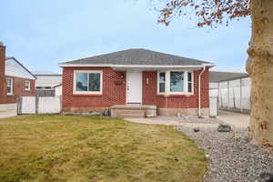View of front of house with roof with shingles and brick siding