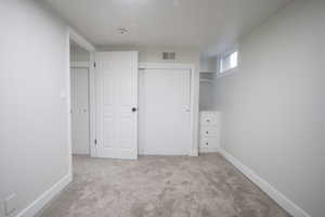 Unfurnished bedroom featuring a closet and light carpet