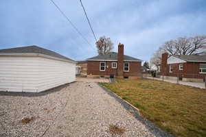 Back of house featuring a chimney, a patio, and brick siding