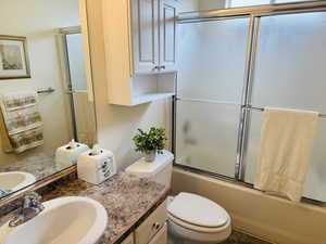 Full bathroom with shower / bath combination with glass door and vanity