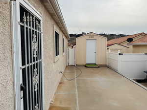 View of patio with a shed
