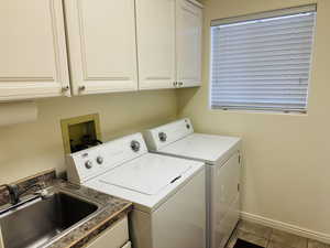 Laundry room featuring cabinet space and washer and clothes dryer