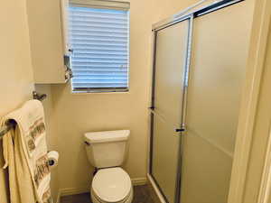 Bathroom featuring a stall shower and a textured wall