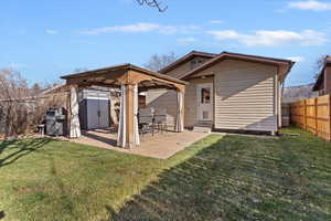 Back of property featuring a patio area, a gazebo, a shed, and a fenced backyard