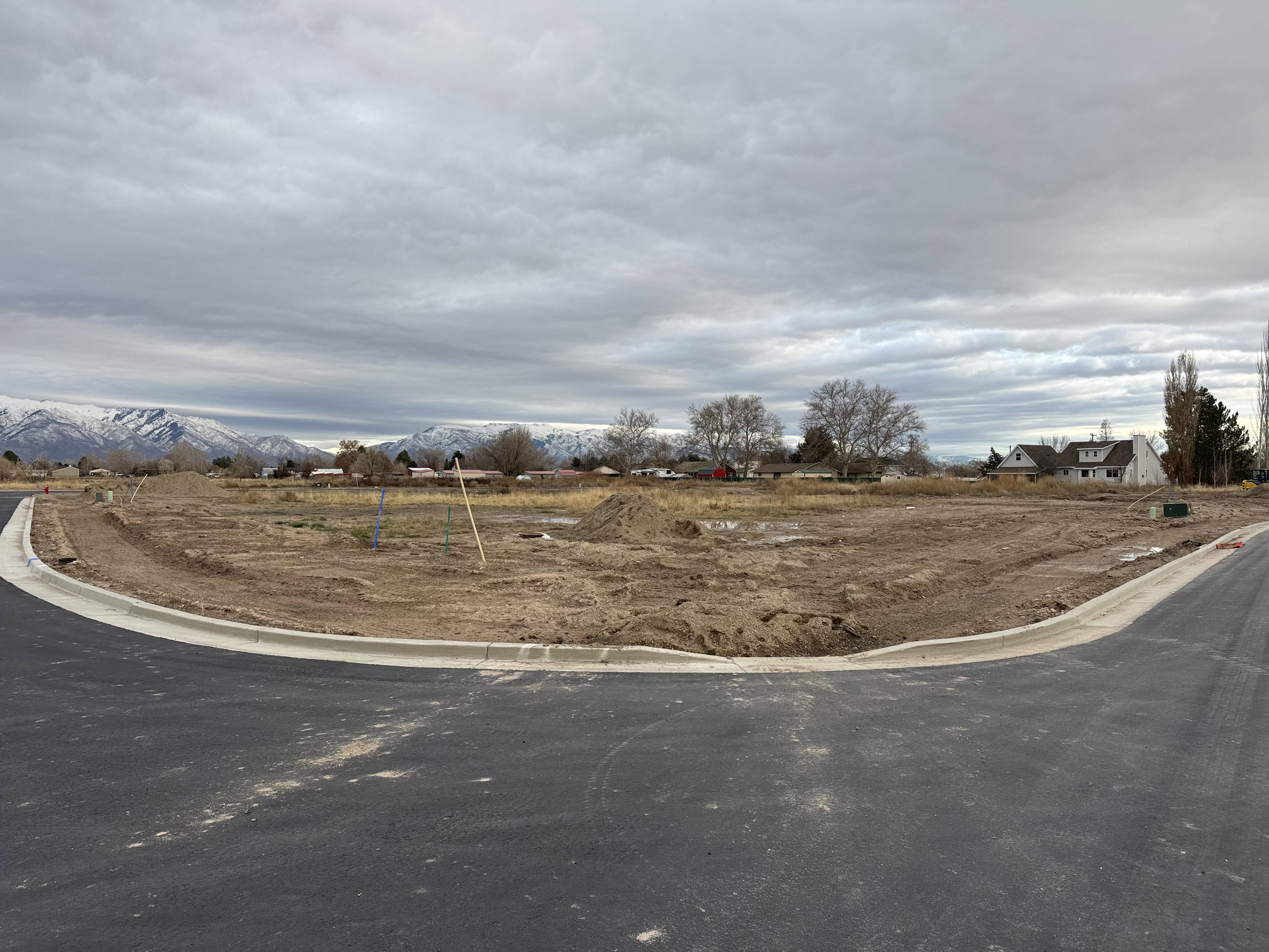 View of asphalt road with curbs, a rural view, and a mountain view
