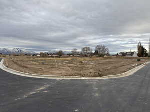 View of asphalt road with curbs, a rural view, and a mountain view