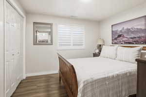 Bedroom with dark wood finished floors and a closet