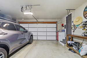 Garage with freestanding refrigerator and a garage door opener