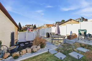 Fenced backyard with a gate, a patio area, and a residential view