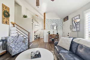 Living area with wood finished floors, stairs, and ceiling fan