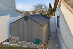 View of property exterior with a residential view and a shed