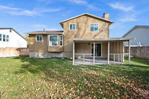 Rear view of house featuring a fenced backyard and a chimney