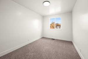 Carpeted spare room with baseboards
