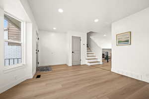 Foyer entrance with light wood-style flooring, stairway, and recessed lighting