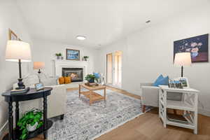 Living area featuring a glass covered fireplace and light wood-style floors