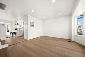 Unfurnished living room featuring healthy amount of natural light, light wood-style floors, and recessed lighting