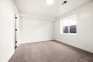 Spare room featuring light carpet and baseboards