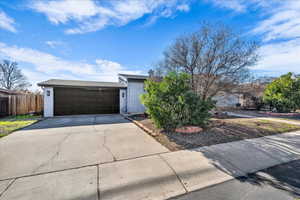 View of front of house with brick siding, driveway, and a garage