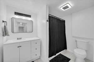 Bathroom featuring a shower with shower curtain and vanity