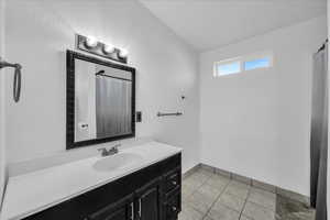 Bathroom with vanity, curtained shower, and light tile patterned floors