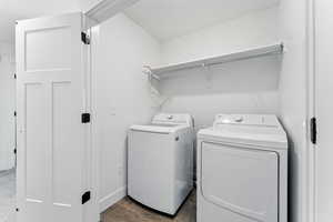 Washroom featuring washer and dryer and wood finished floors