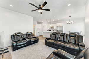 Living area featuring light wood finished floors, a chandelier, recessed lighting, and a ceiling fan