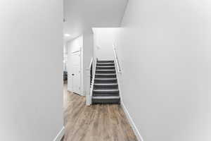 Stairs with recessed lighting and wood finished floors