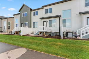 Back of property featuring board and batten siding, a lawn, a residential view, and stucco siding
