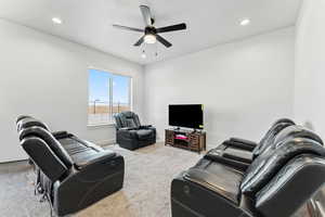 Living room with light colored carpet, recessed lighting, and a ceiling fan