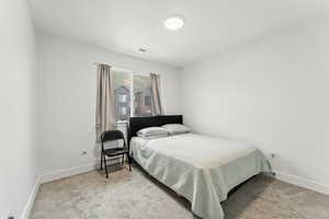 Bedroom with light carpet and baseboards