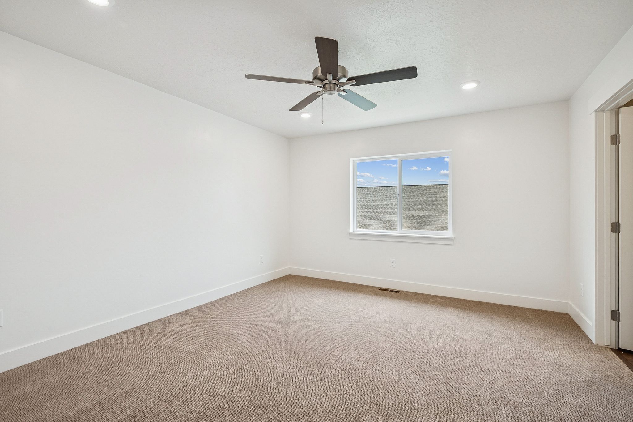 Empty room with light carpet, a ceiling fan, and recessed lighting