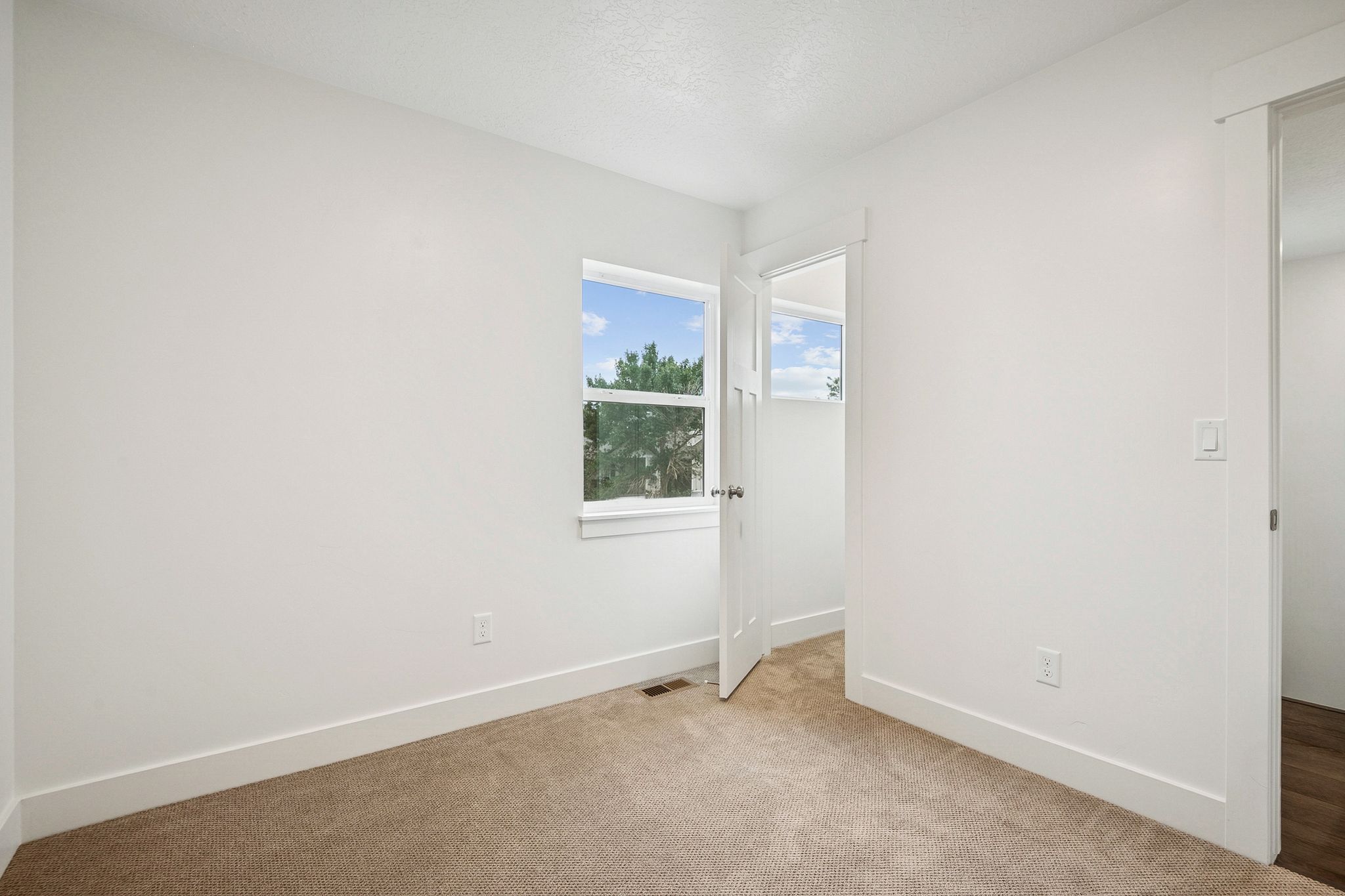Unfurnished bedroom with baseboards and light carpet