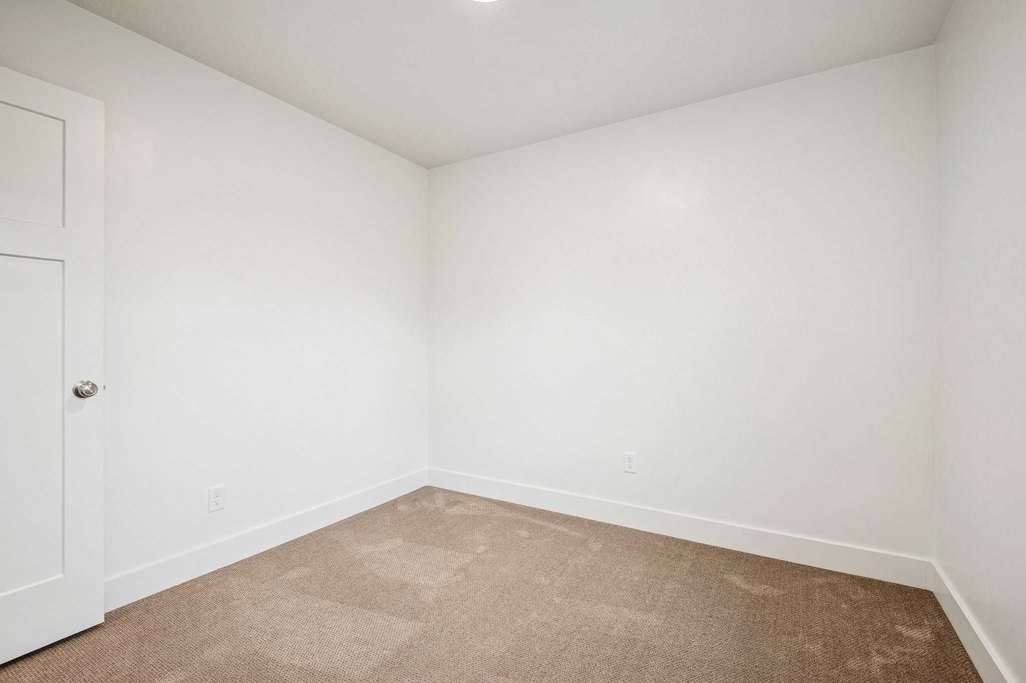 Spare room featuring carpet floors and baseboards