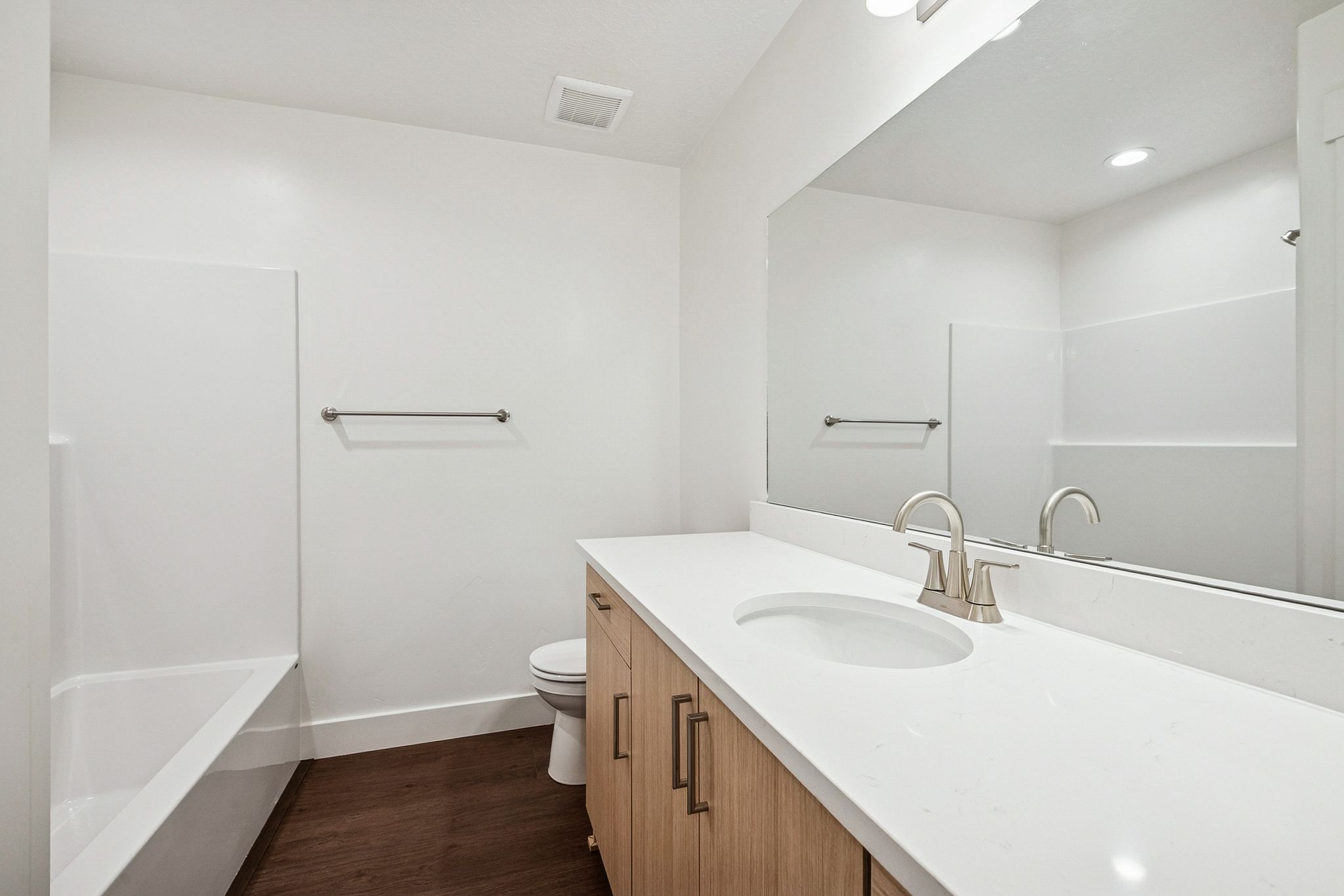 Full bathroom featuring vanity, dark wood-style floors, and shower / tub combination