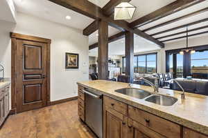 Kitchen featuring open floor plan, decorative light fixtures, dark wood-style floors, dishwasher, and beamed ceiling