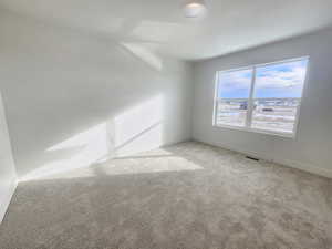 Spare room with baseboards and carpet floors