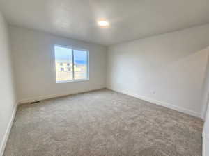 Empty room featuring baseboards and carpet flooring