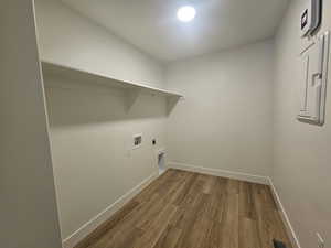 Washroom featuring light wood finished floors, hookup for an electric dryer, electric panel, and washer hookup