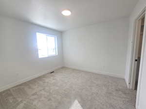Unfurnished room featuring light colored carpet and baseboards