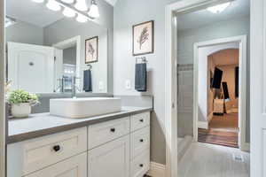 Full bath featuring vanity, a textured ceiling, and tiled shower