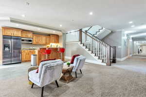 Living room with ornamental molding, recessed lighting, stairs, light carpet, and a textured ceiling