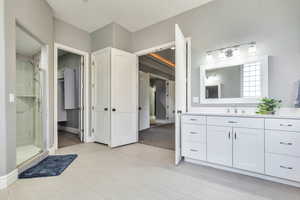 Bathroom with vanity, a stall shower, and a spacious closet